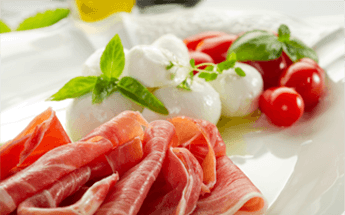 Platter of meats, cheeses, and tomatoes