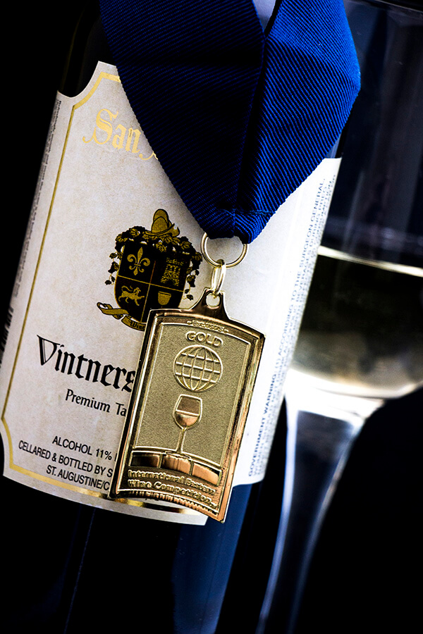 Bottle of Vintners Red with a gold competition medal around the neck