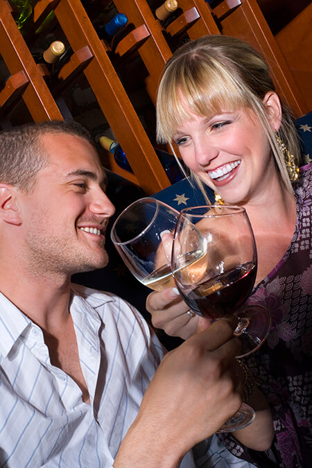 Young man and woman toasting with wine glasses